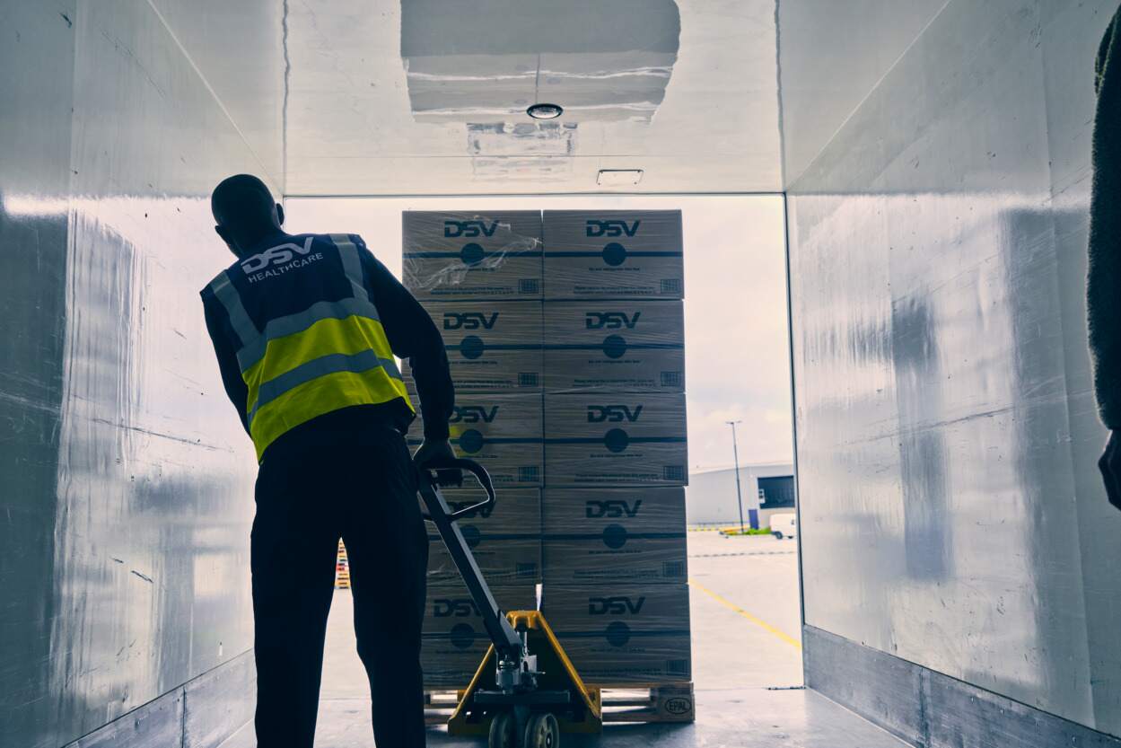 DSV medarbeider triller gods ut av lasteplan.